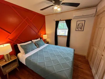 a bedroom with a blue bed with an orange wall at Wally's Compound in Hawley