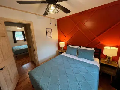 a bedroom with a blue bed with an orange wall at Wally's Cabin in Hawley