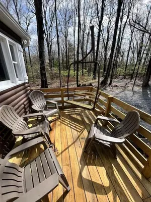 a deck with two chairs and a bench on a house at Wally's Cabin in Hawley