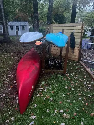 a red kayak sitting next to a bench and a sleeping bag at Wally's Cabin in Hawley