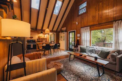 a living room with a couch and a table at Family Pocono Gem by the lake with private sauna, hot tub, and huge game room in Arrowhead Lake