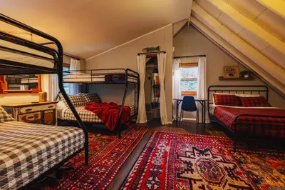 a bedroom with two bunk beds and a rug at Family Pocono Gem by the lake with private sauna, hot tub, and huge game room in Arrowhead Lake