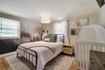 a bedroom with a bed and a crib at Family Pocono Gem by the lake with private sauna, hot tub, and huge game room in Arrowhead Lake