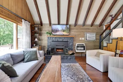 a living room with a couch and a fireplace at Family Pocono Gem by the lake with private sauna, hot tub, and huge game room in Arrowhead Lake