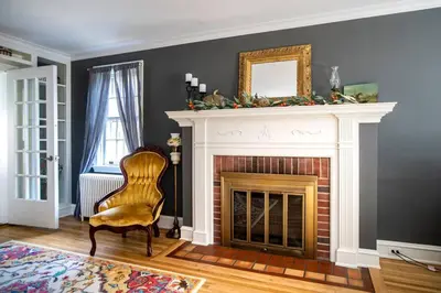 a living room with a fireplace and a chair at Beautiful fully-furnished Colonial in Millersville in Millersville
