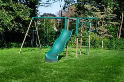 a playground with a green slide in the grass at Beautiful fully-furnished Colonial in Millersville in Millersville