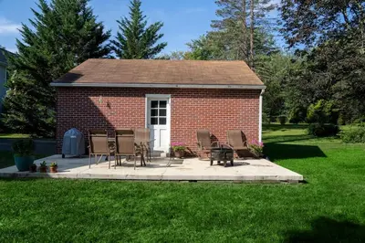 a small brick building with chairs and a table at Beautiful fully-furnished Colonial in Millersville in Millersville