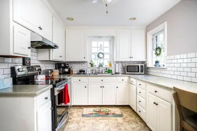 a white kitchen with white cabinets and a sink at Beautiful fully-furnished Colonial in Millersville in Millersville