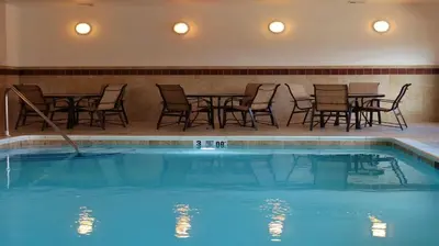 a swimming pool with chairs and a table and a table and chairsitures at Holiday Inn Express and Suites Montgomery by IHG in Montgomery