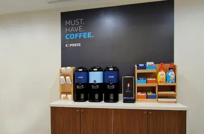 a counter with bottles of coffee on it at Holiday Inn Express and Suites Montgomery by IHG in Montgomery