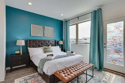 a bedroom with blue walls and a bed with a bench at 3 Mi to Center City Philadelphia Townhome in Philadelphia