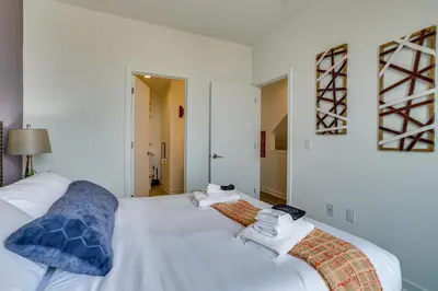 a bedroom with a white bed with towels on it at 3 Mi to Center City Philadelphia Townhome in Philadelphia
