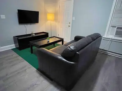 a living room with a brown couch and a table at THE ECO HOME. Entire place with private parking in Wilmington