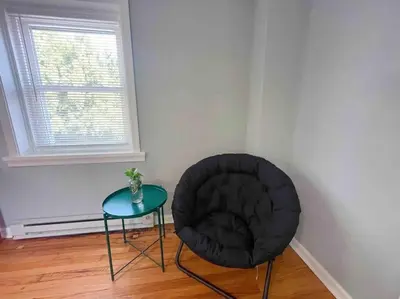 a black chair and a table in a room at THE ECO HOME. Entire place with private parking in Wilmington