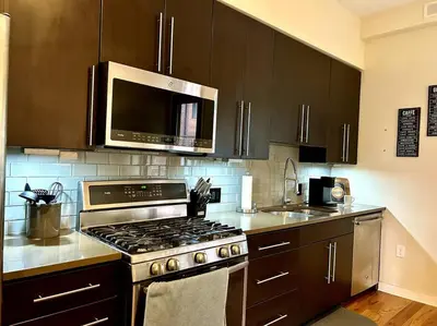 a kitchen with a stove and a microwave at The Fishtown Blue Jay - Garage Parking Included! in Philadelphia