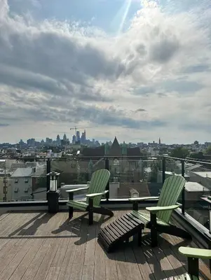 two green chairs sitting on a deck with a view of a city at The Fishtown Blue Jay - Garage Parking Included! in Philadelphia