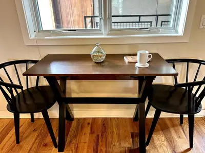 a wooden table with two chairs and a coffee mug on it at The Fishtown Blue Jay - Garage Parking Included! in Philadelphia