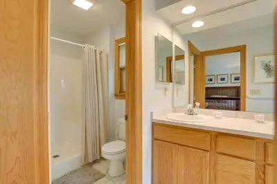 a bathroom with a toilet and a sink and a mirror at Less Than 1 Mi to Camelback Resort Home with Pool Table! in Tannersville