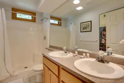 a bathroom with two sinks and a toilet and a mirror at Less Than 1 Mi to Camelback Resort Home with Pool Table! in Tannersville