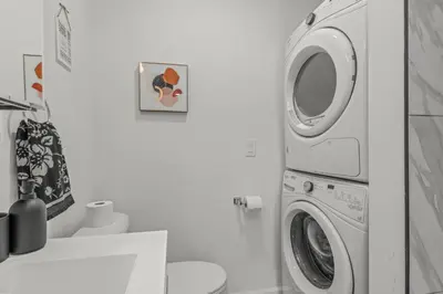 a washer and dryer in a white bathroom at Stay Rafa At 259 in Philadelphia