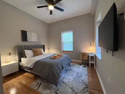 a bedroom with a bed and a flat screen tv at Stay Rafa At 259 in Philadelphia