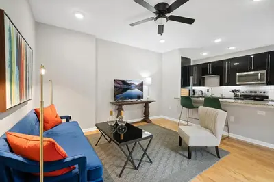 a living room with a blue couch and a kitchen at Stay Rafa At 259 in Philadelphia