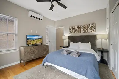 a bedroom with a large bed and a flat screen tv at Stay Rafa At 259 in Philadelphia
