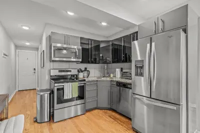 a kitchen with stainless steel appliances and wooden floors at Stay Rafa At 259 in Philadelphia