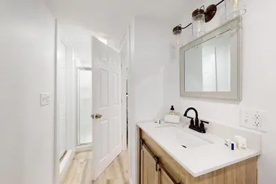 a white bathroom with a sink and a mirror at Heaven on Lake Harmony in Lake Harmony