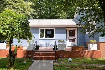 a blue house with a porch and a patio at 3 Acre Lake Paradise Swimming Pool & Jacuzzi HotTub! in Hopatcong
