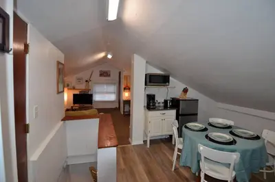 a dining room and kitchen with a table and chairs at Cozy Alcove Studio Apt w Outdoor deck w NYC Views in Jersey City
