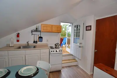 a kitchen with a sink and a stove and a table at Cozy Alcove Studio Apt w Outdoor deck w NYC Views in Jersey City