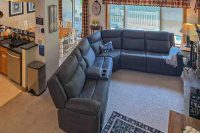a living room with a leather couch and a kitchen at Maple Manor in Tannersville