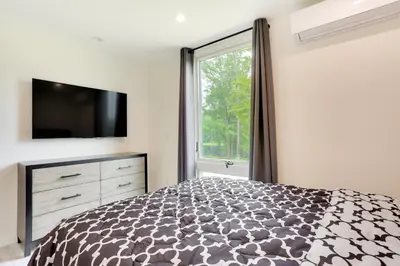 a bedroom with a bed and a large window at Lakefront Catskills Container Home Private Lake in Swan Lake
