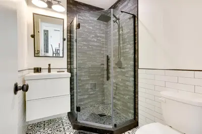 a bathroom with a glass shower and a toilet at Lakefront Catskills Container Home Private Lake in Swan Lake