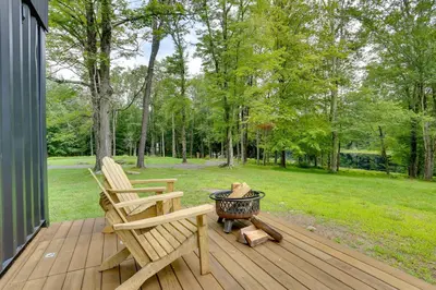 two chairs sitting on a deck with a grill at Lakefront Catskills Container Home Private Lake in Swan Lake