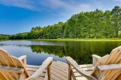 two chairs sitting on a dock next to a lake at Lakefront Catskills Container Home Private Lake in Swan Lake