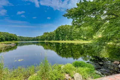 a view of a lake with trees and grass at Lakefront Catskills Container Home Private Lake in Swan Lake