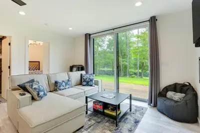 a living room with a couch and a table at Lakefront Catskills Container Home Private Lake in Swan Lake
