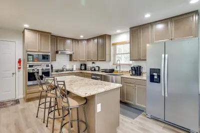 a kitchen with wooden cabinets and a white refrigerator at Hot Tub and Lake Access Spacious Tobyhanna Home in Tobyhanna