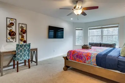 a bedroom with a bed and a desk and a ceiling fan at Hot Tub and Lake Access Spacious Tobyhanna Home in Tobyhanna