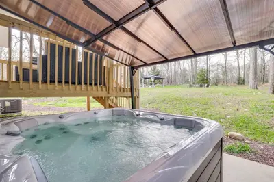 a hot tub in a backyard with a wooden roof at Hot Tub and Lake Access Spacious Tobyhanna Home in Tobyhanna