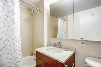 a bathroom with a sink and a mirror at Chelsea 1BR w Roof deck Gym Doorman NYC-122 in New York