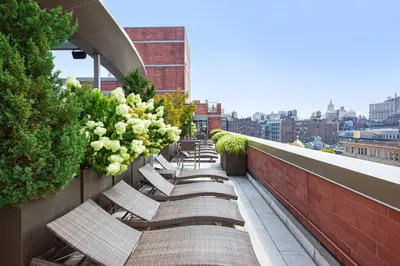 a row of chairs sitting on a balcony at Chelsea 1BR w Roof deck Gym Doorman NYC-122 in New York