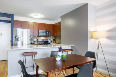 a kitchen and dining room with a wooden table and chairs at Chelsea 1BR w Roof deck Gym Doorman NYC-122 in New York