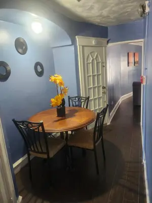 a dining room table with chairs and a vase of flowers on it at The Spot in Stonehurst