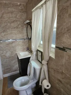 a bathroom with a toilet and a sink and a window at The Spot in Stonehurst