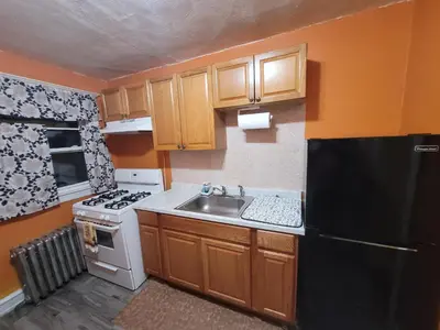 a small kitchen with a sink and a black refrigerator at The Spot in Stonehurst