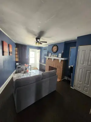 a living room with a couch and a clock on the wall at The Spot in Stonehurst