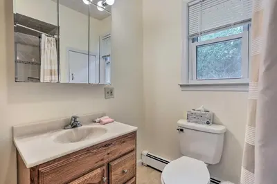 a bathroom with a sink and a toilet and a window at Spacious Lakefront House With a Private Dock in Hopatcong